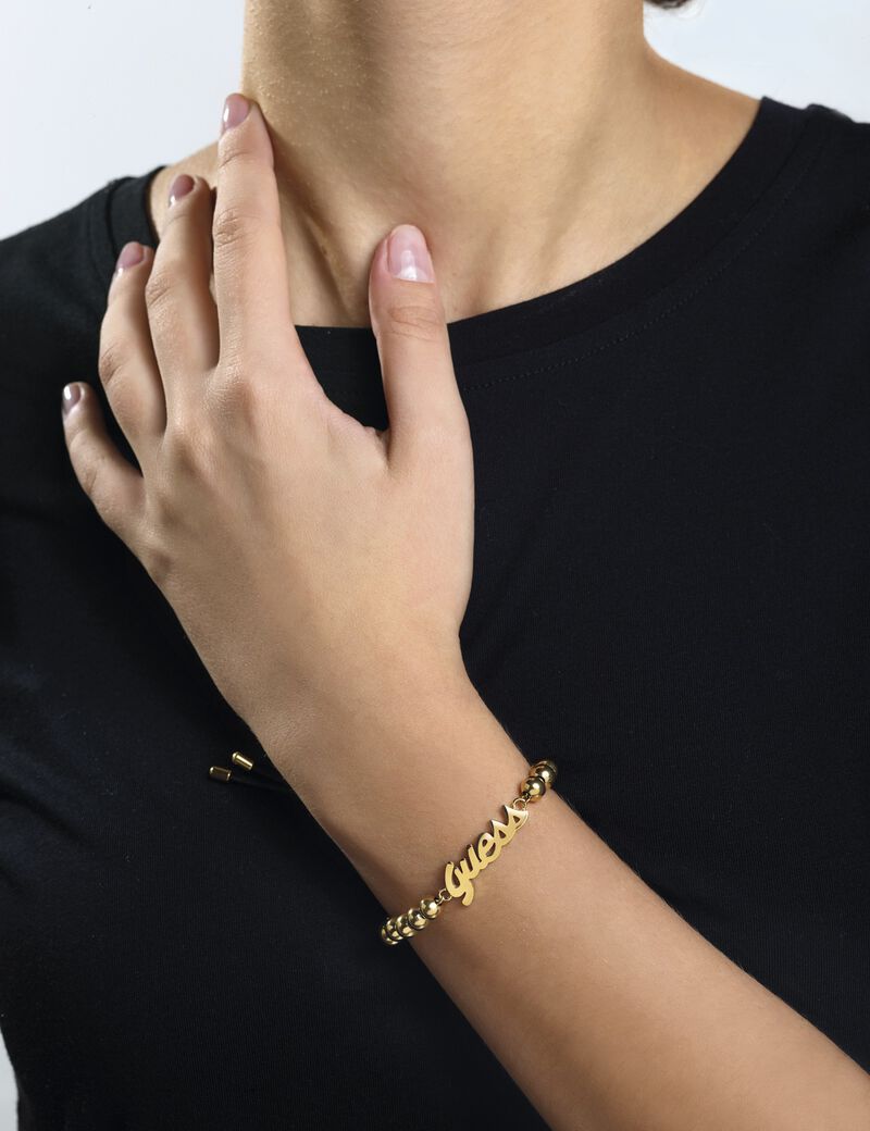 سوار باللونين الذهبي والأسود مُزدان بخرز ويتوسطه شعار